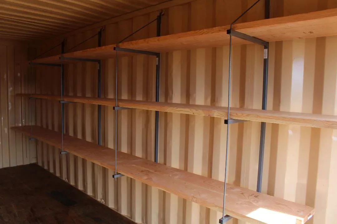 Same container interior now fitted with three tiers of heavy-duty wood shelving mounted on steel